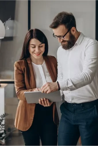 Two people reviewing information on a tablet